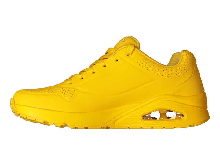 Tenis deportivos Skechers color amarillo brillante con suela amortiguada y detalles perforados.