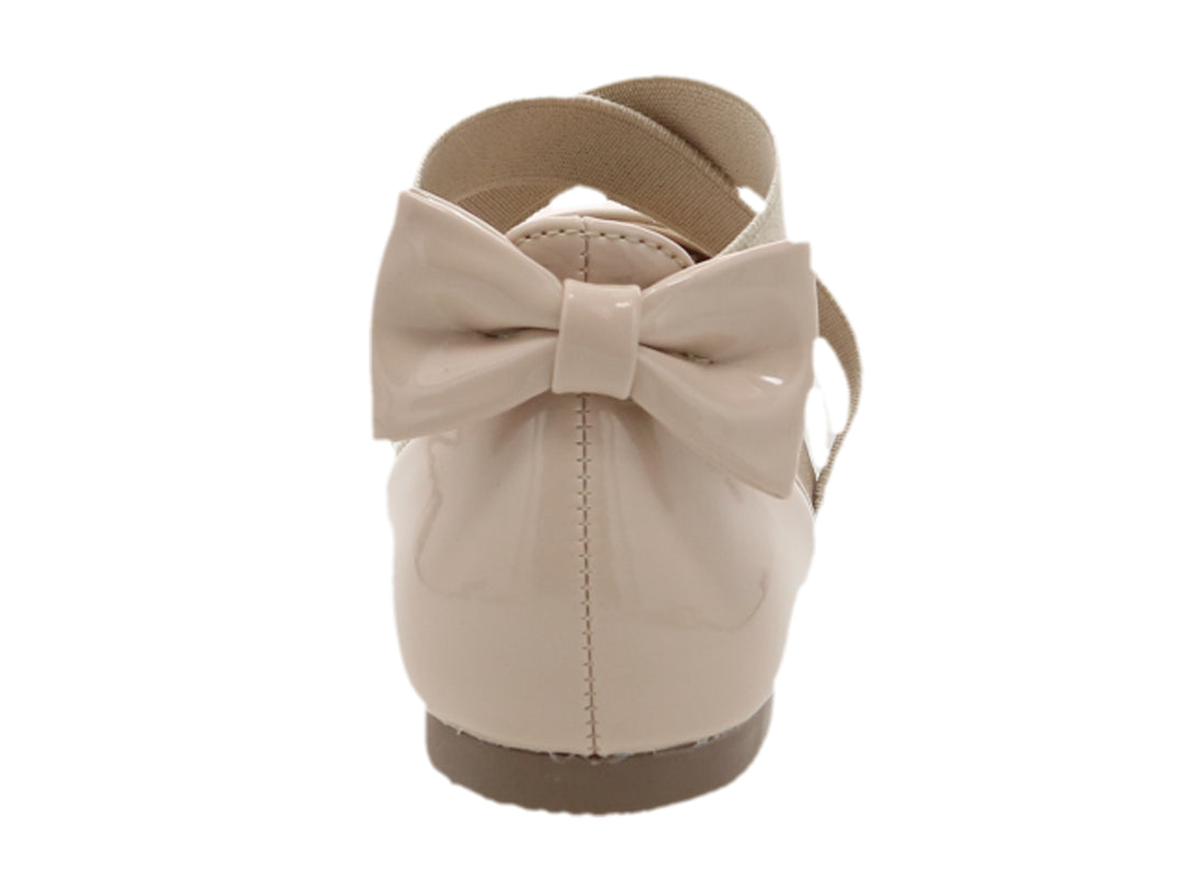 Zapato plano para Niña en color rosa de charol brillante con correas cruzadas y detalle de moño posterior.