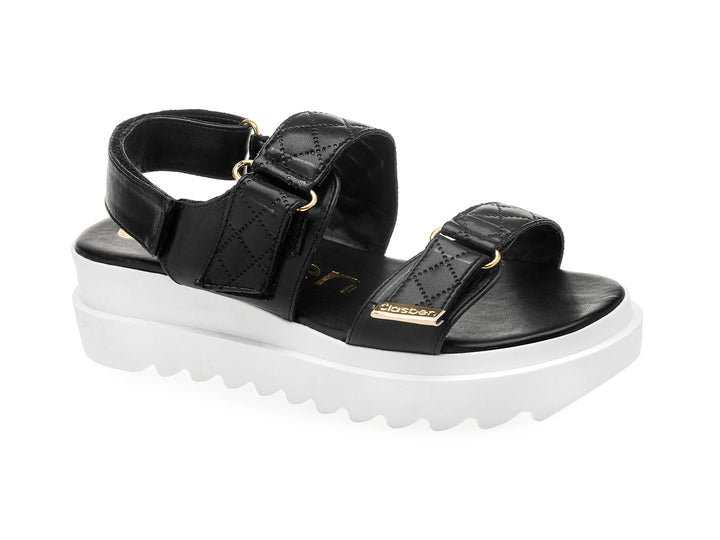 Sandalia negra de plataforma blanca con correas acolchadas y hebillas doradas para mujer.
