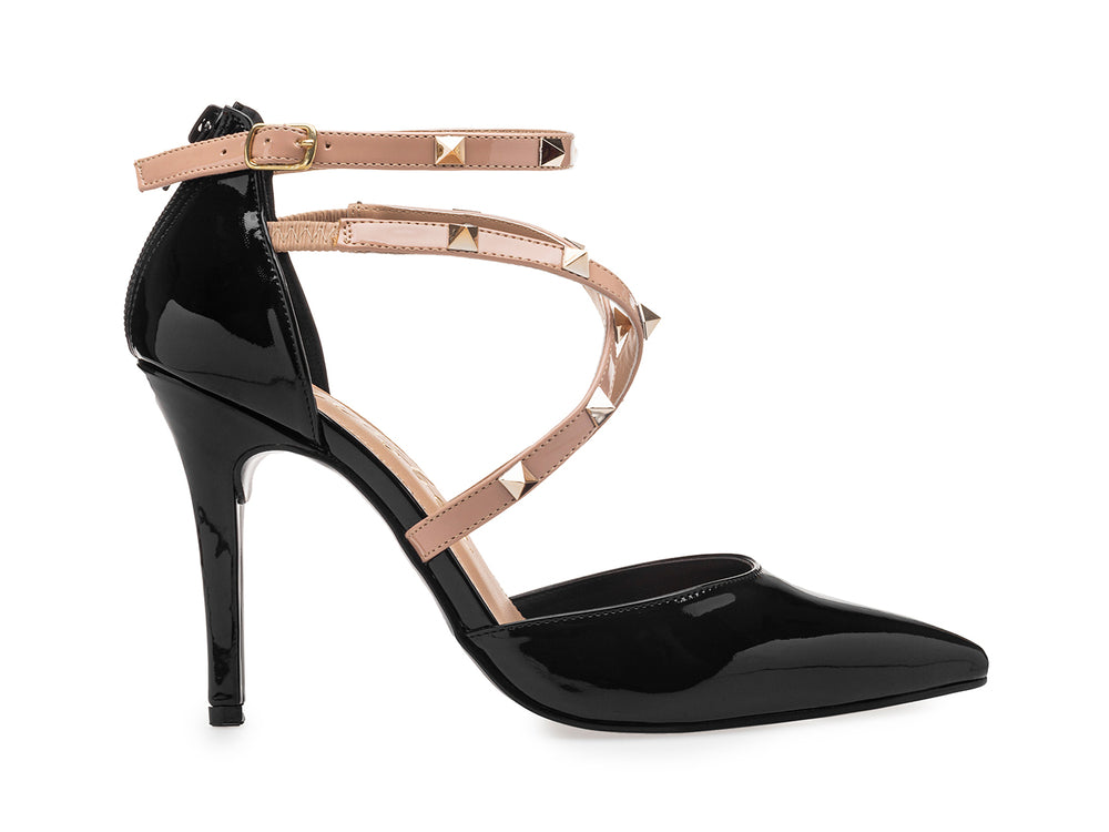 Zapato de tacón alto negro brillante con tiras beige decoradas con estoperoles dorados y punta fina.