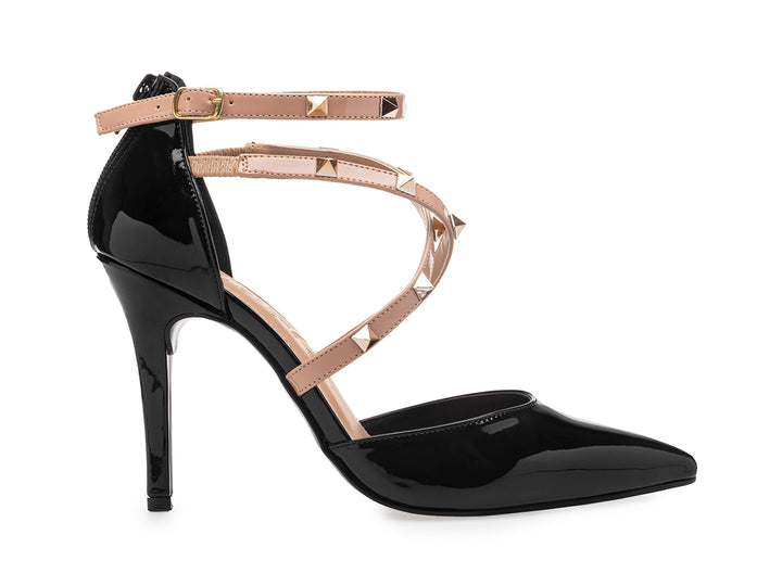 Zapato de tacón alto negro brillante con tiras beige decoradas con estoperoles dorados y punta fina.