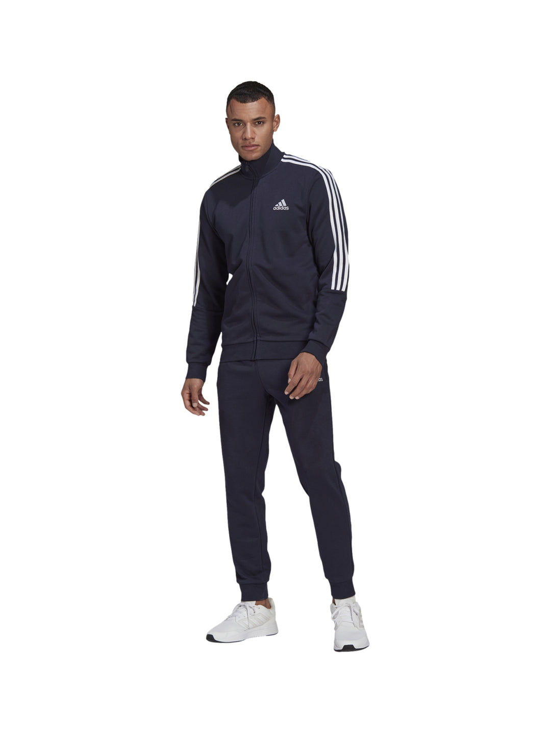 Hombre vistiendo conjunto deportivo Adidas azul marino con tres franjas blancas laterales.