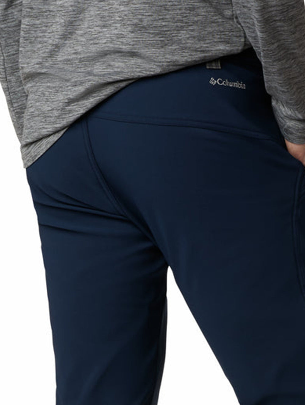 Hombre vistiendo pantalón de senderismo Columbia en color azul marino con calzado gris.