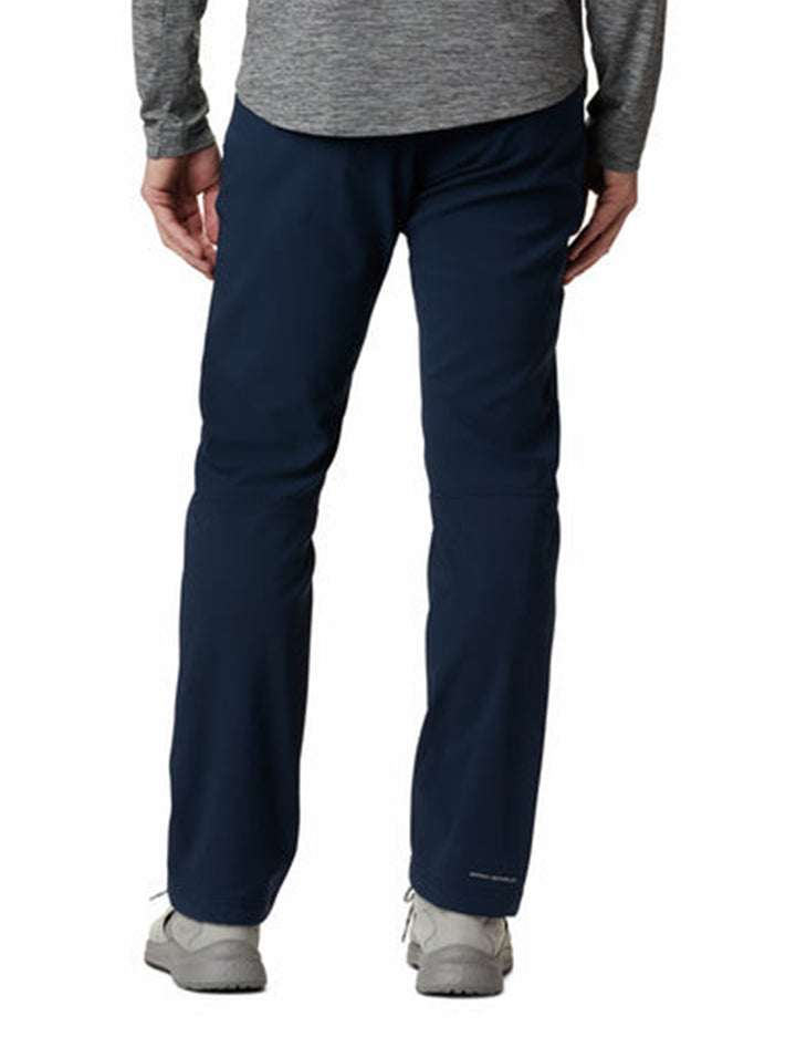 Hombre vistiendo pantalón de senderismo Columbia en color azul marino con calzado gris.