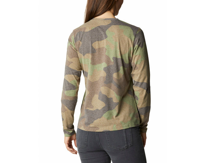 Mujer vistiendo camiseta de manga larga Columbia con estampado de camuflaje en tonos verdes y grises.