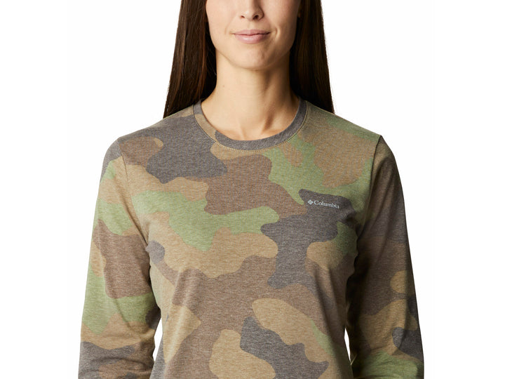 Mujer vistiendo camiseta de manga larga Columbia con estampado de camuflaje en tonos verdes y grises.