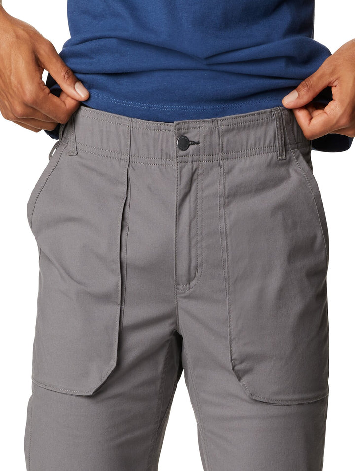 Hombre usando pantalones utilitarios color gris Columbia con bolsillos laterales.
