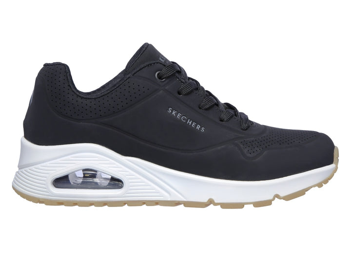 Tenis deportivos Skechers color negro con suela blanca y amortiguación visible en el talón.