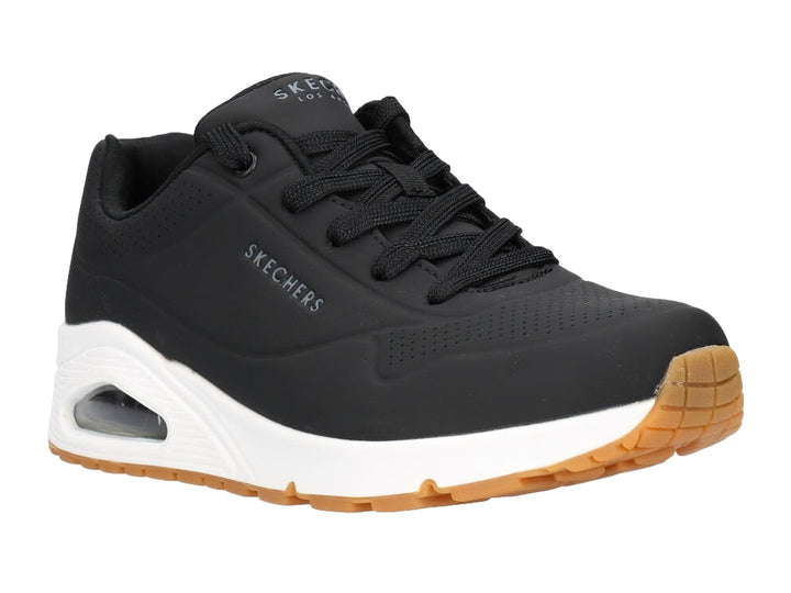 Tenis deportivos Skechers color negro con suela blanca y amortiguación visible en el talón.