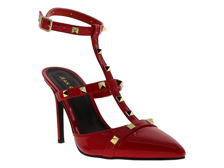 Zapato de tacón rojo de charol con punta fina, correa al tobillo y detalles de estoperoles dorados.