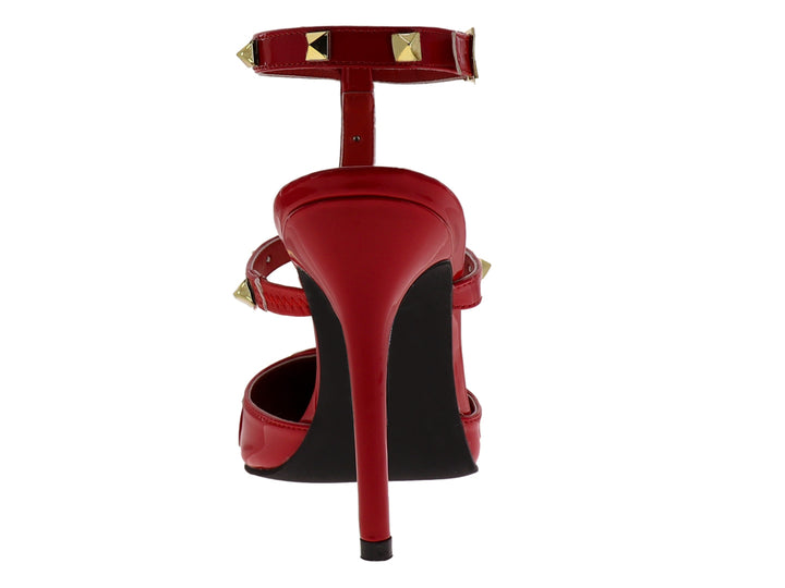Zapato de tacón rojo de charol con punta fina, correa al tobillo y detalles de estoperoles dorados.