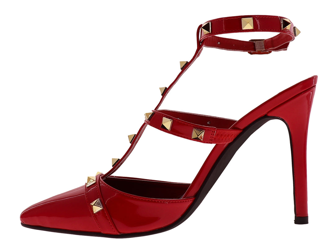 Zapato de tacón rojo de charol con punta fina, correa al tobillo y detalles de estoperoles dorados.