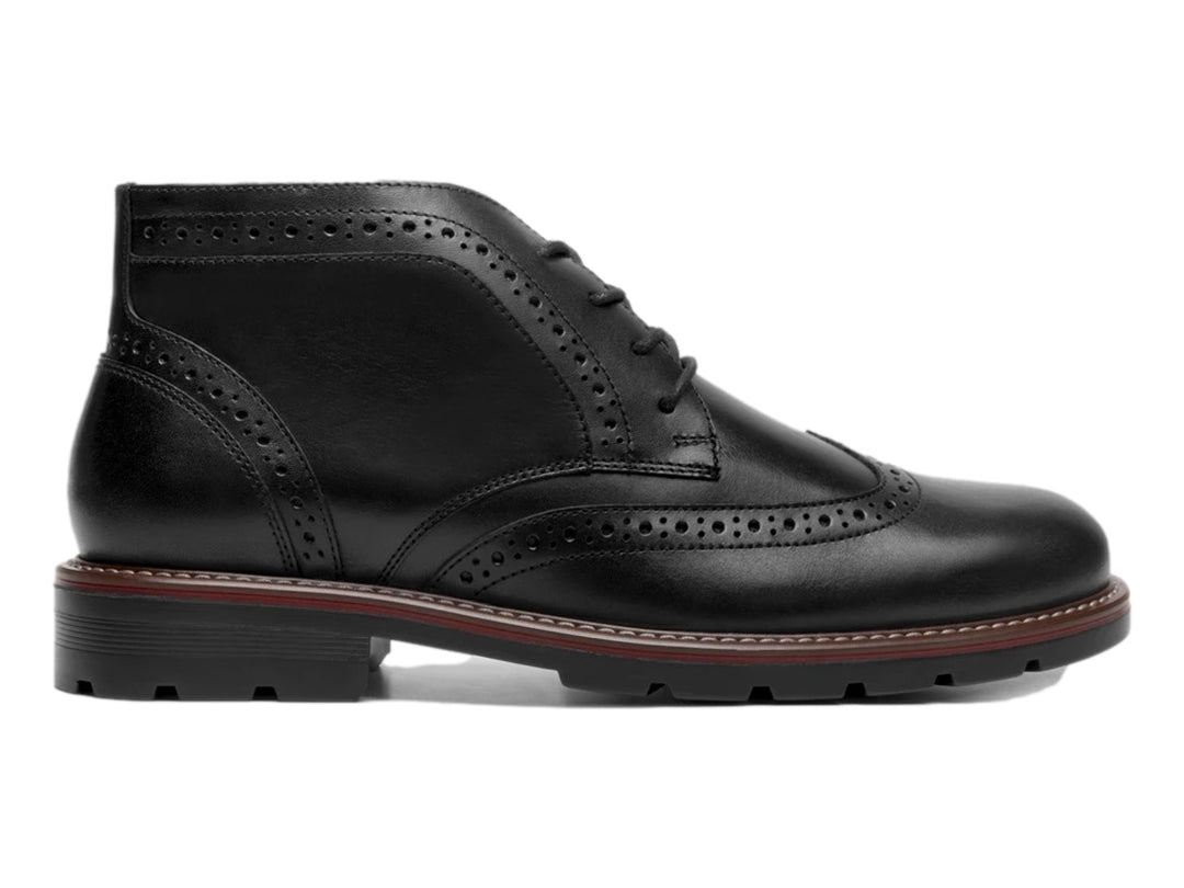 Bota negra de cuero con detalles perforados tipo brogue y suela track.