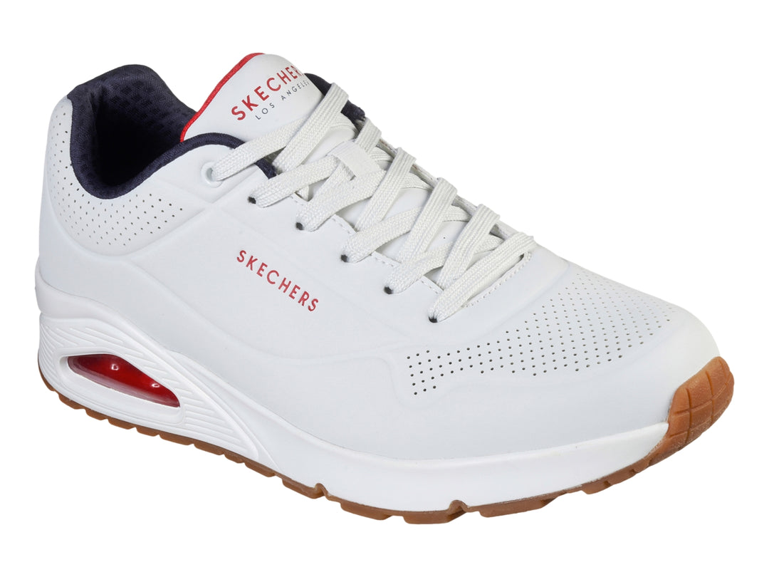 Tenis Skechers blancos con suela color miel y cámara de aire visible en el talón.