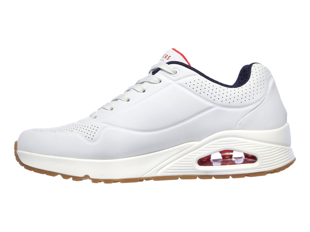 Tenis Skechers blancos con suela color miel y cámara de aire visible en el talón.