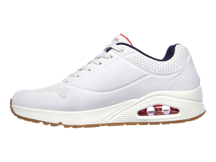 Tenis Skechers blancos con suela color miel y cámara de aire visible en el talón.