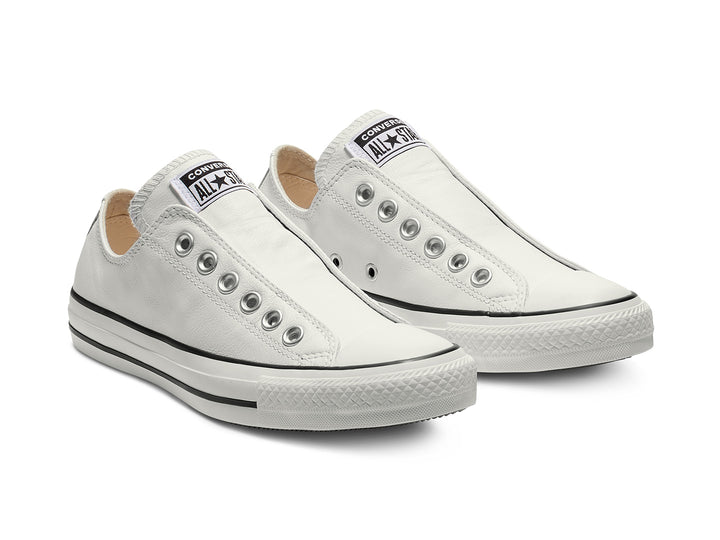 Tenis Converse Chuck Taylor All Star de cuero blanco estilo slip-on con ojillos metálicos.