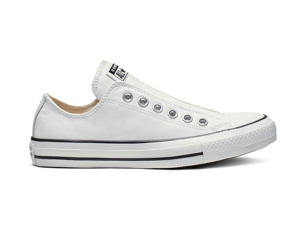 Tenis Converse Chuck Taylor All Star de cuero blanco estilo slip-on con ojillos metálicos.