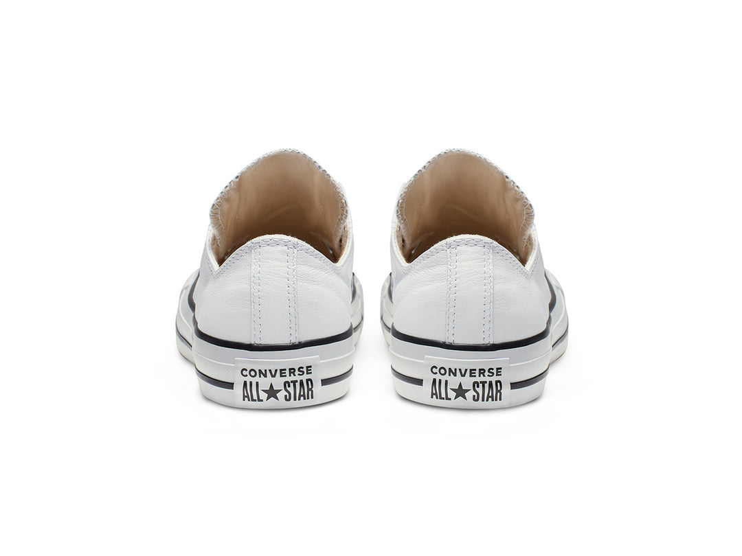Tenis Converse Chuck Taylor All Star de cuero blanco estilo slip-on con ojillos metálicos.