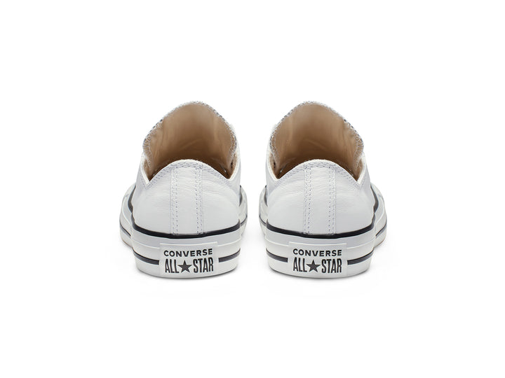 Tenis Converse Chuck Taylor All Star de cuero blanco estilo slip-on con ojillos metálicos.
