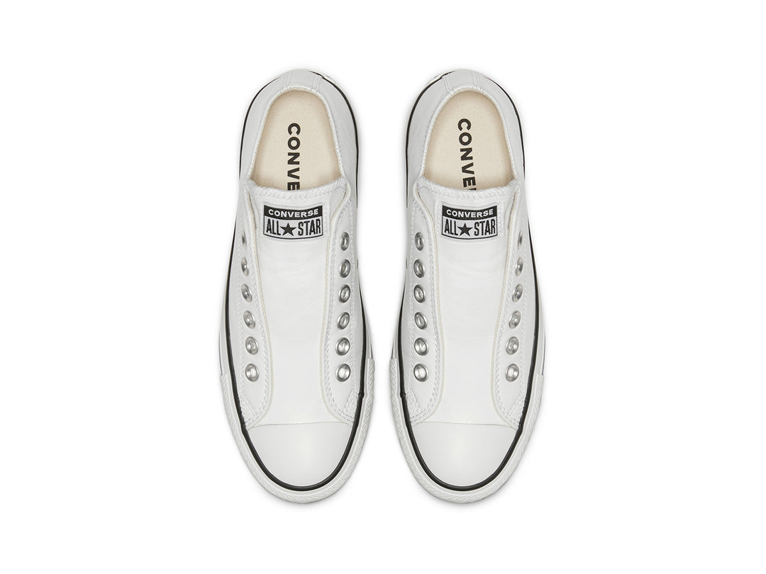 Tenis Converse Chuck Taylor All Star de cuero blanco estilo slip-on con ojillos metálicos.