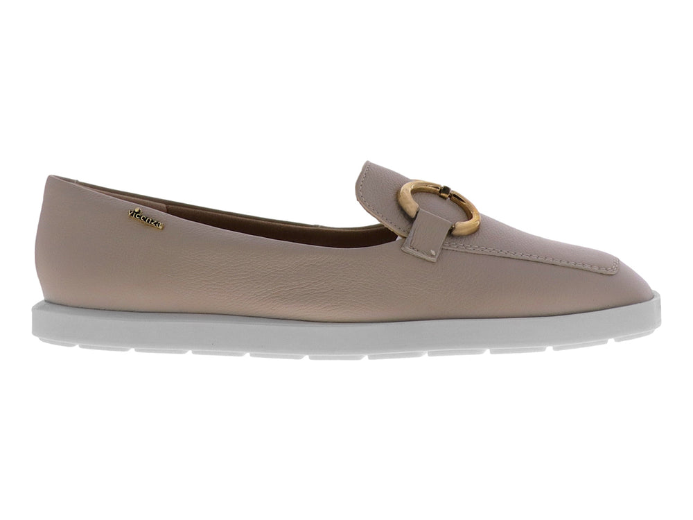 Mocasín color almendra para mujer con hebilla dorada y suela blanca.