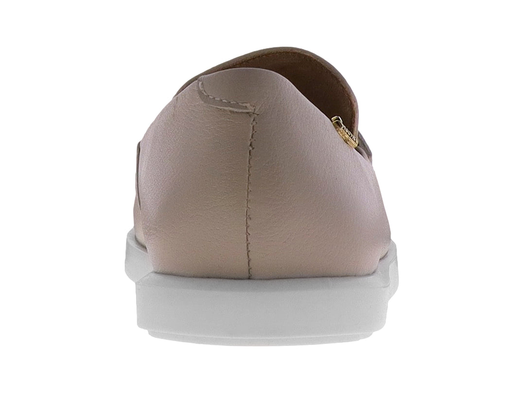 Mocasín color almendra para mujer con hebilla dorada y suela blanca.