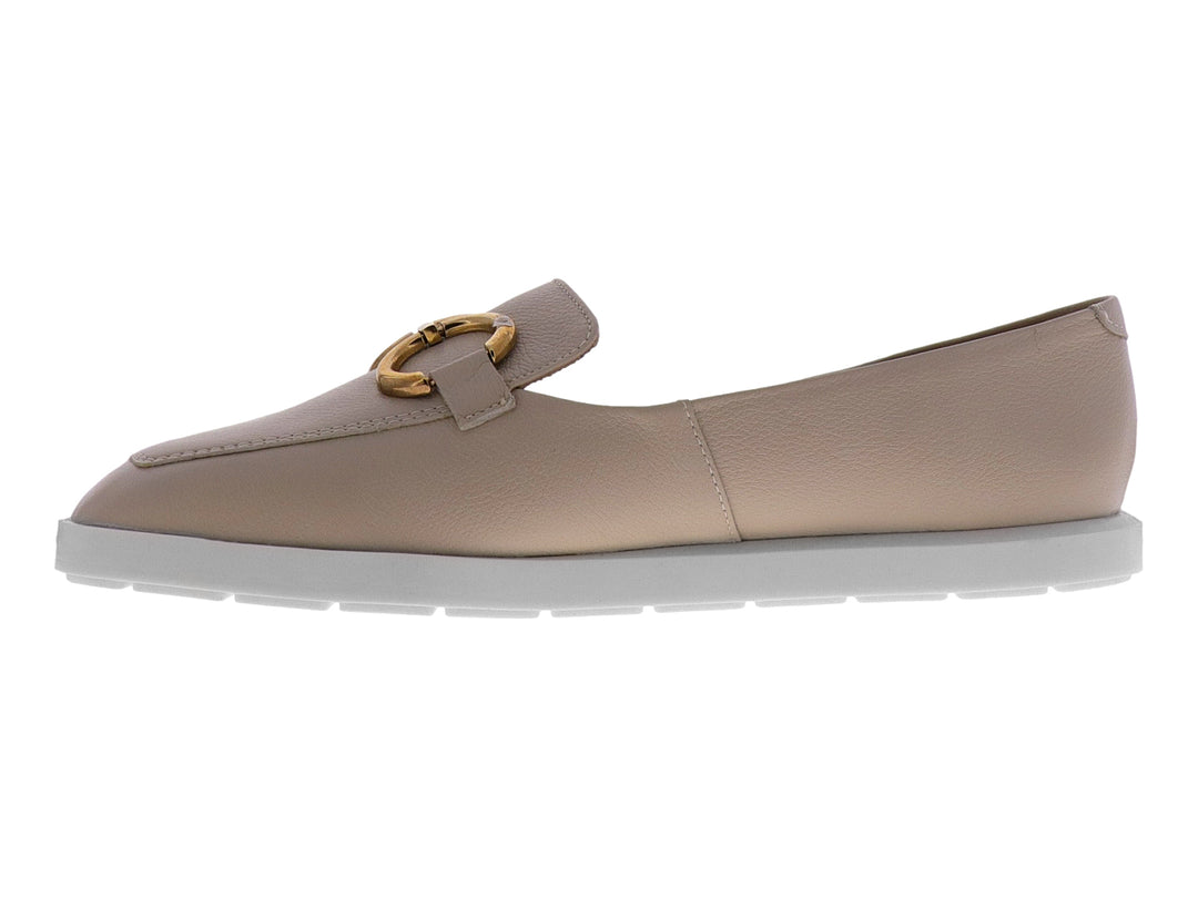Mocasín color almendra para mujer con hebilla dorada y suela blanca.