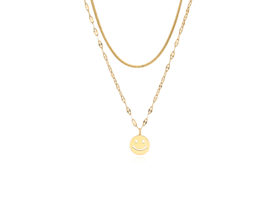 Collar de doble cadena en color oro con un dije circular de carita feliz.