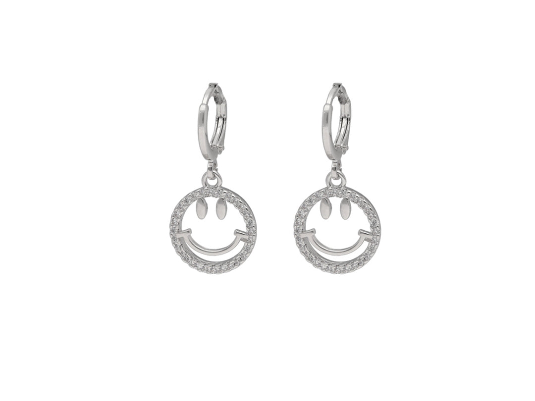 Par de aretes plateados con dije circular en forma de carita feliz adornada con brillantes.