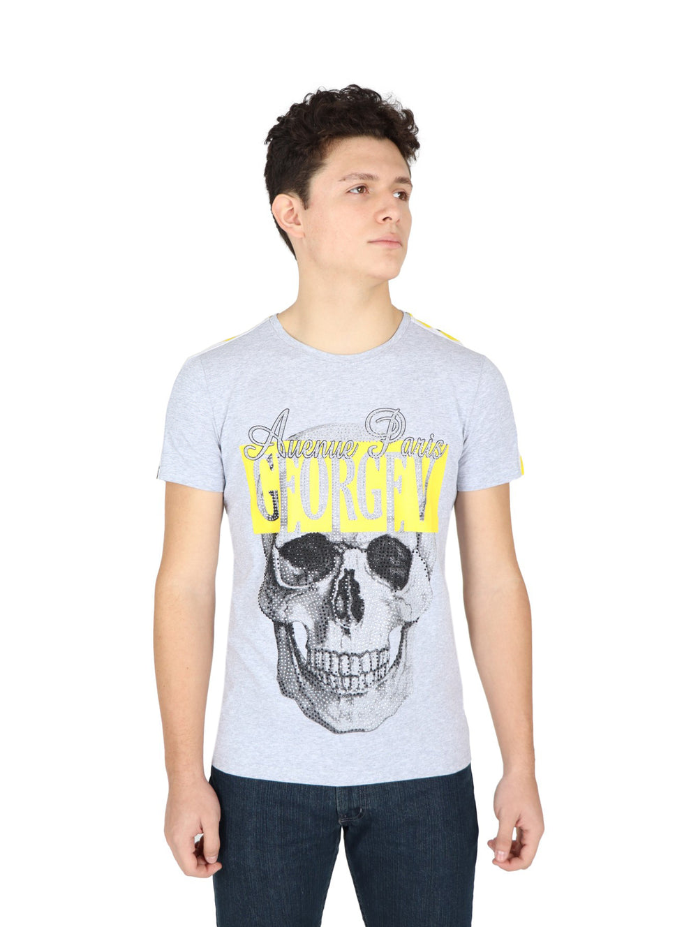Hombre vistiendo playera gris de manga corta con estampado de calavera y letras amarillas en el pecho.