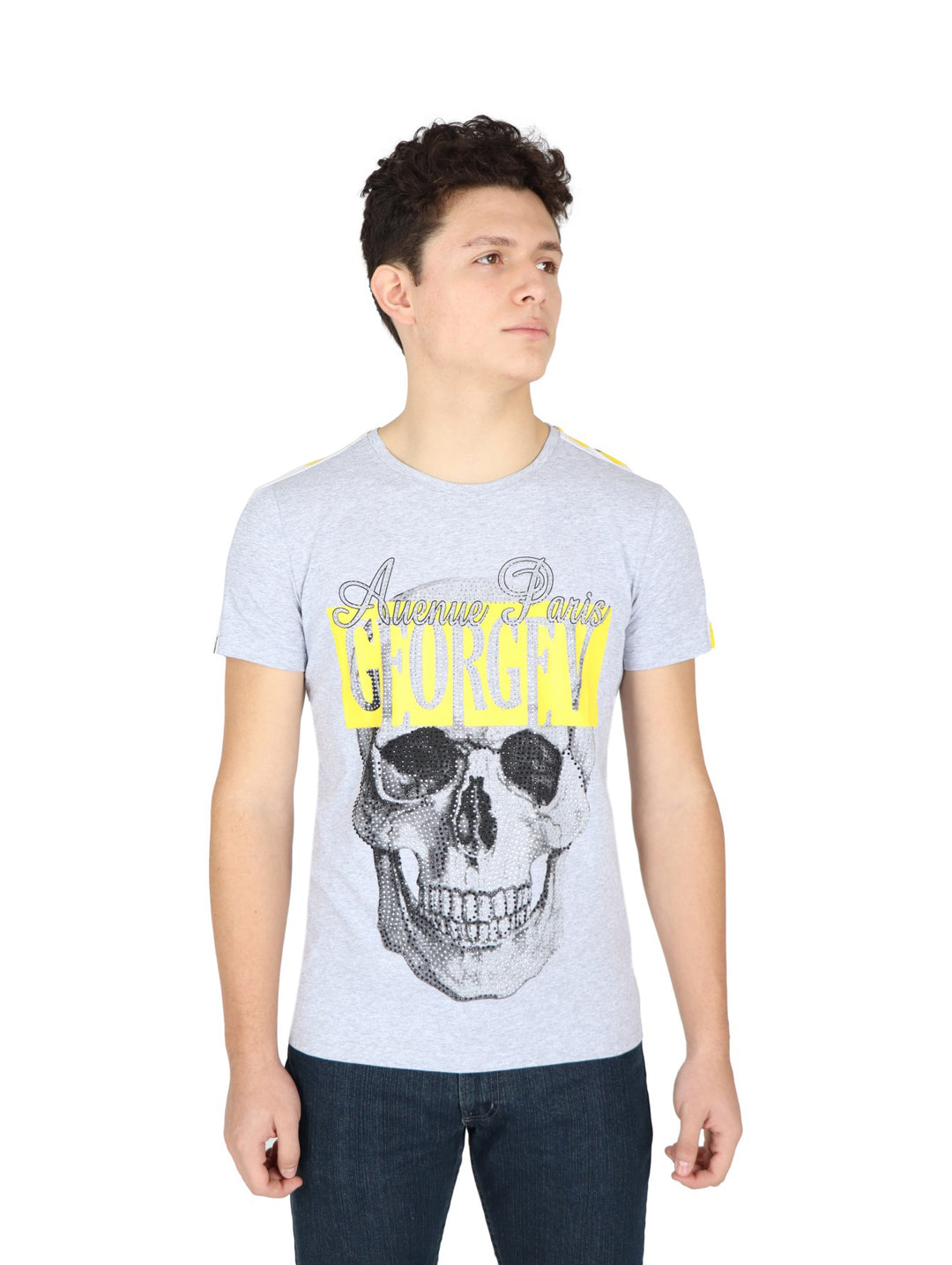 Hombre vistiendo playera gris de manga corta con estampado de calavera y letras amarillas en el pecho.