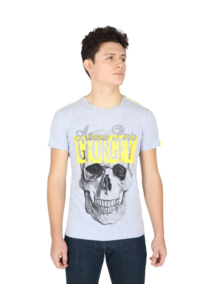 Hombre vistiendo playera gris de manga corta con estampado de calavera y letras amarillas en el pecho.