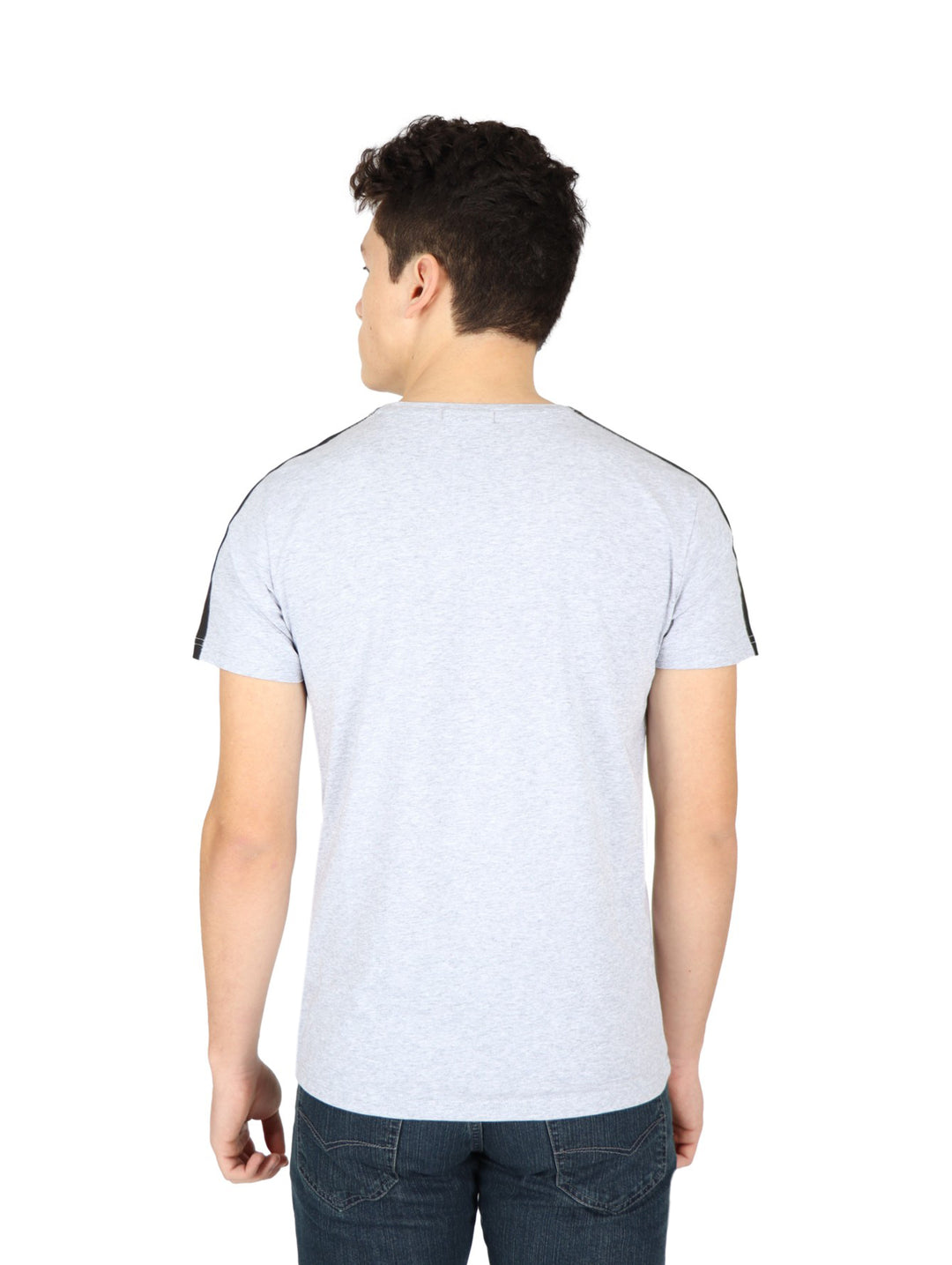 Hombre vistiendo playera gris de manga corta con estampado de calavera y letras amarillas en el pecho.