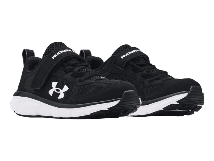Tenis deportivos Under Armour color negro con suela blanca y correa de ajuste.