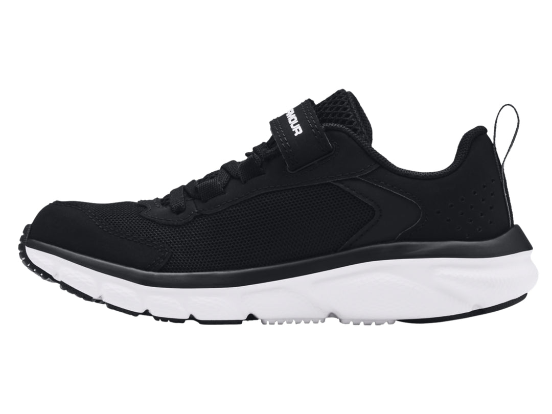 Tenis deportivos Under Armour color negro con suela blanca y correa de ajuste.