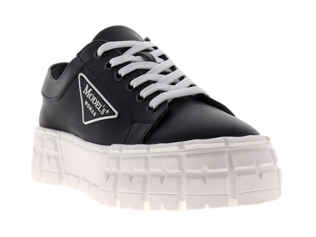 Tenis negros para mujer con suela de plataforma blanca ancha y agujetas blancas.