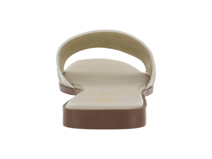 Sandalia plana color beige con textura de cocodrilo y hebilla dorada decorativa.
