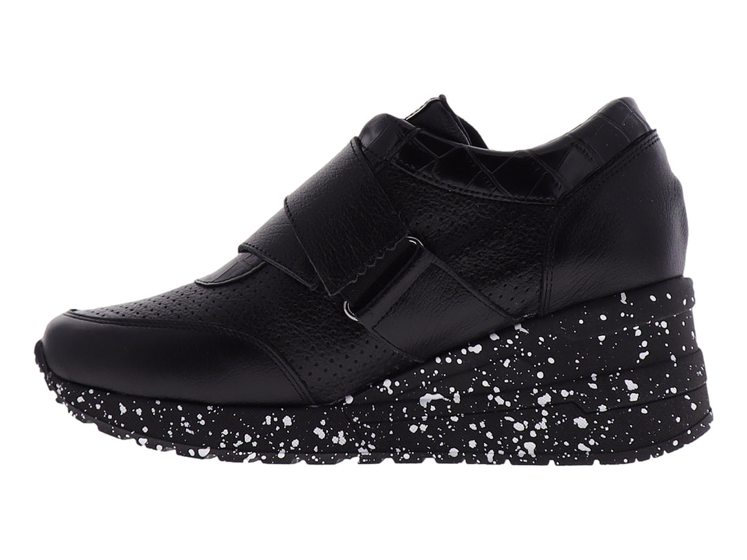 Zapato confort negro para mujer con suela blanca moteada y correa decorativa con logo MANET.