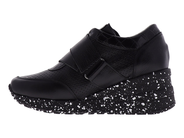 Zapato confort negro para mujer con suela blanca moteada y correa decorativa con logo MANET.