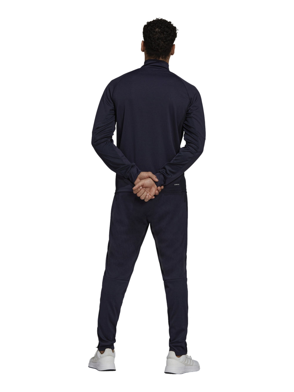 Hombre vistiendo conjunto deportivo Adidas color azul marino con rayas blancas laterales.
