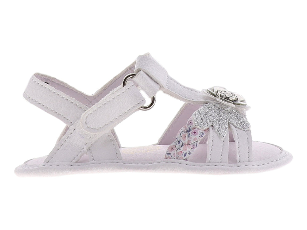 Sandalia blanca para bebé con detalle de flor plateada y brillante en la parte superior.