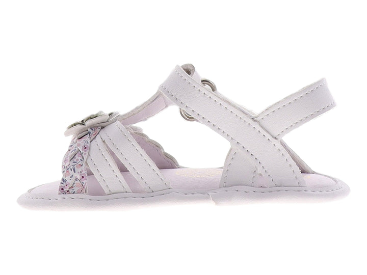Sandalia blanca para bebé con detalle de flor plateada y brillante en la parte superior.