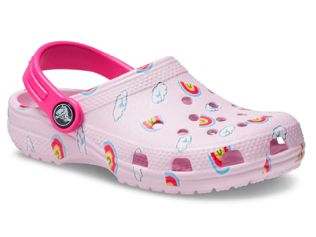 Zuecos Crocs color rosa para niña con diseño de arcoíris y nubes y correa rosa fuerte.