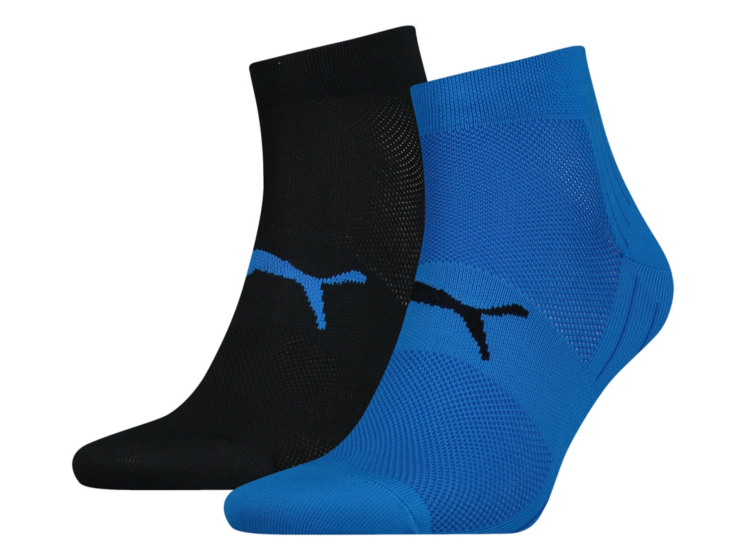 Par de calcetines deportivos PUMA en colores azul y negro con logotipos contrastantes.