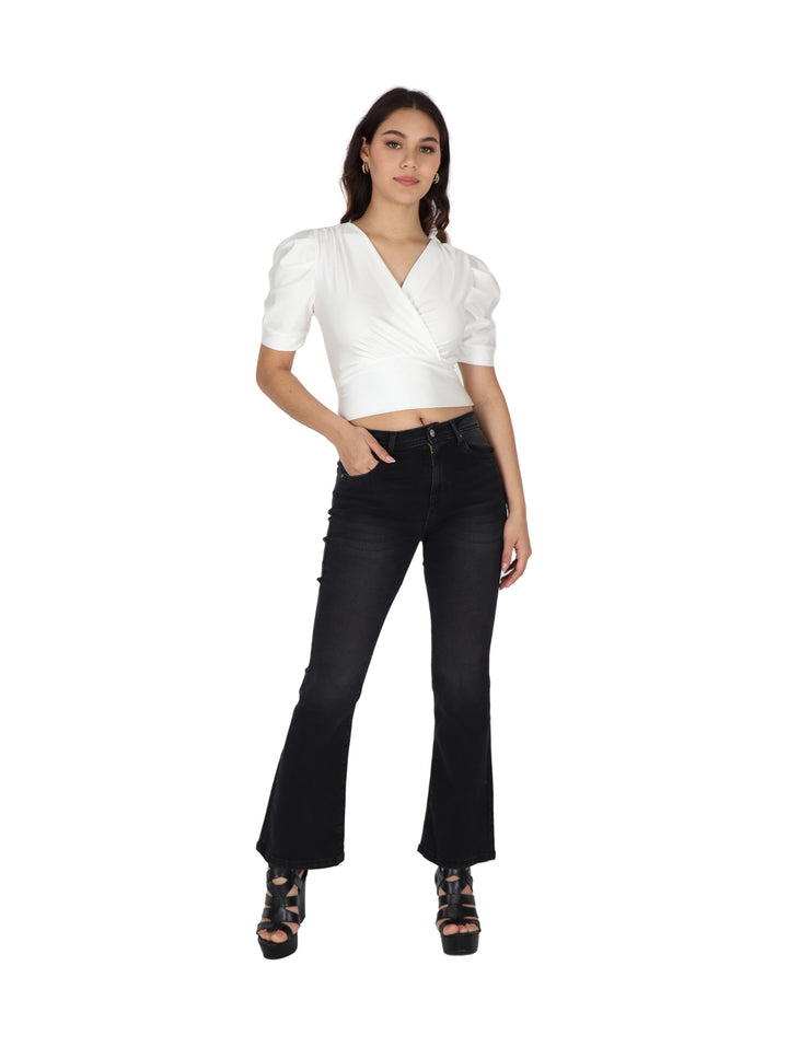 Mujer vistiendo blusa color ivory con cuello en V, cruce frontal y mangas bombacha cortas.