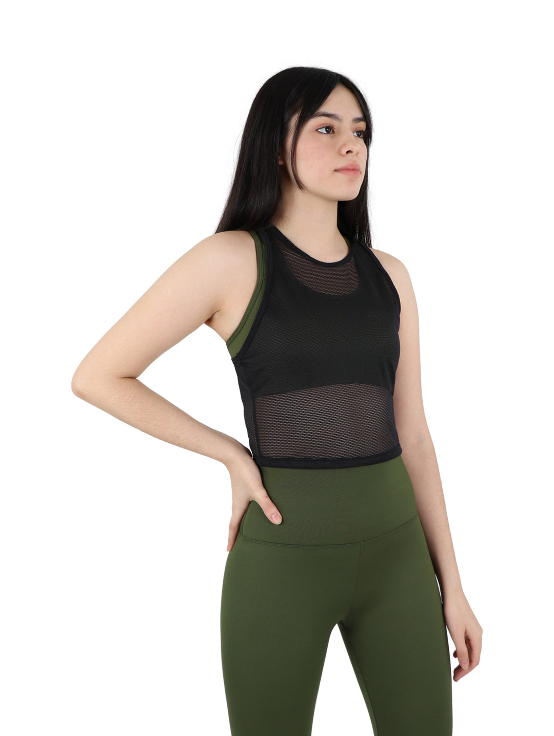 Mujer vistiendo un top crop deportivo negro perforado y leggings verde oliva sobre fondo blanco.