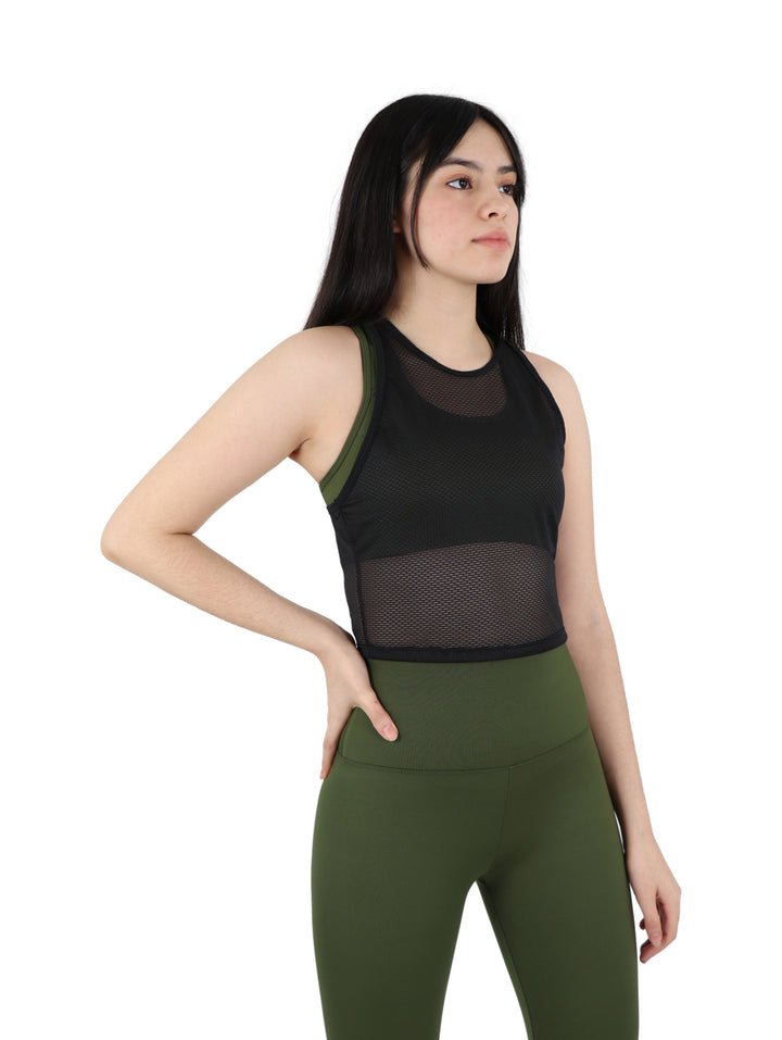 Mujer vistiendo un top crop deportivo negro perforado y leggings verde oliva sobre fondo blanco.