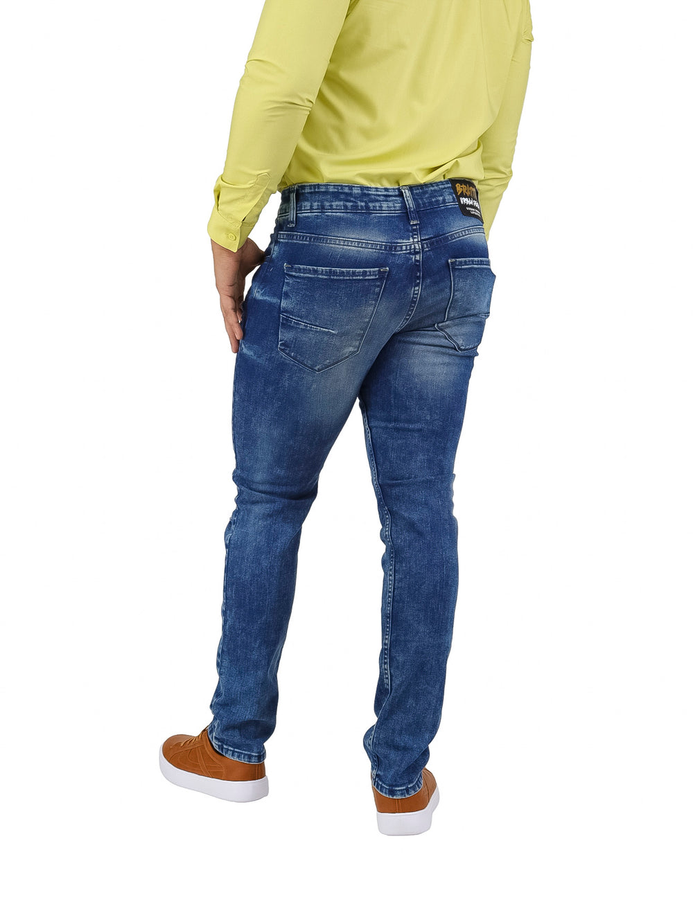 Hombre vistiendo pantalones jeans slim fit color azul con detalles de desgaste y roturas frontales.