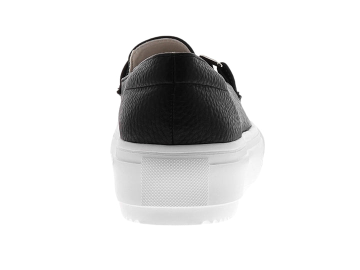 Zapato mocasín negro con suela de plataforma blanca y detalle de hebilla plateada.